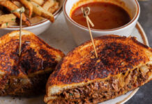 Where to Brunch in Sugar Land A grilled sandwich cut in halves on a plate with fries and a sauce dip