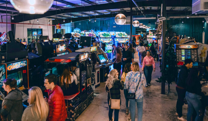 People walking through rows of arcade games